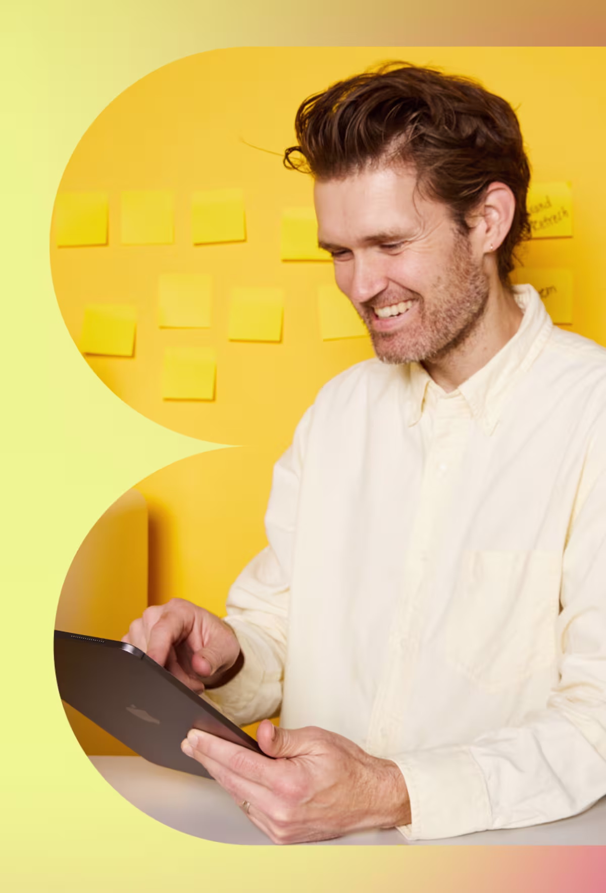 Image of a smiling man pointing at a tablet